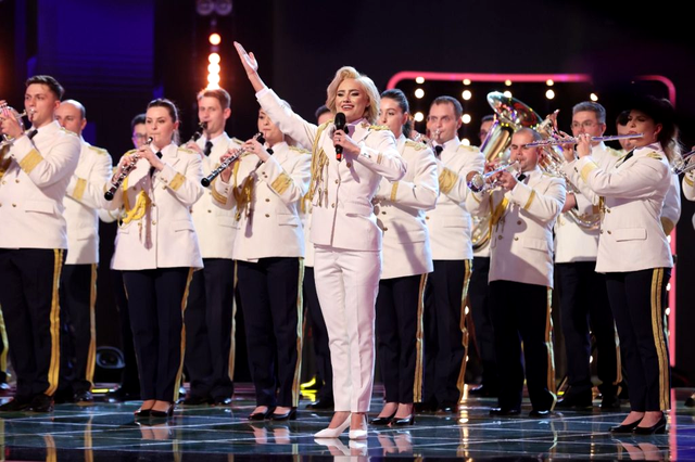 Artista, pe scenă, alături de orchestra militară